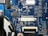 A detailed view of a blue printed circuit board with various electronic components such as capacitors, resistors, and integrated circuits. The board features visible traces and connections, along with labeled components and reference numbers.
