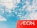 A clear blue sky with scattered white clouds provides a backdrop for a prominent red sign featuring the word 'AEON' in white letters.