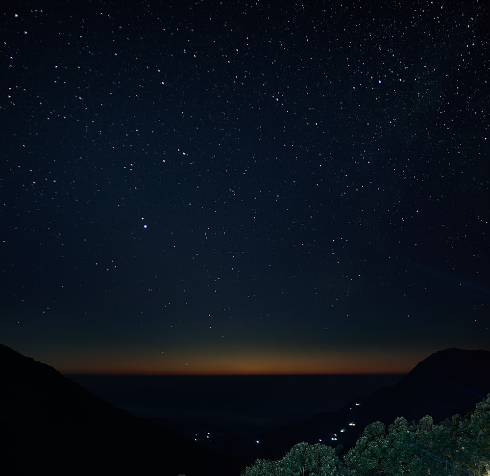 silhouette of mountain under starry night