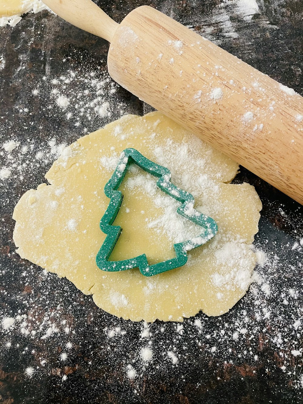 brown wooden rolling pin on white dough