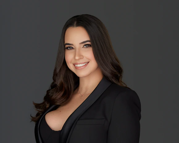 Portrait of a confident woman smiling, showcasing her sleek, newly styled hair after a smoothing treatment.