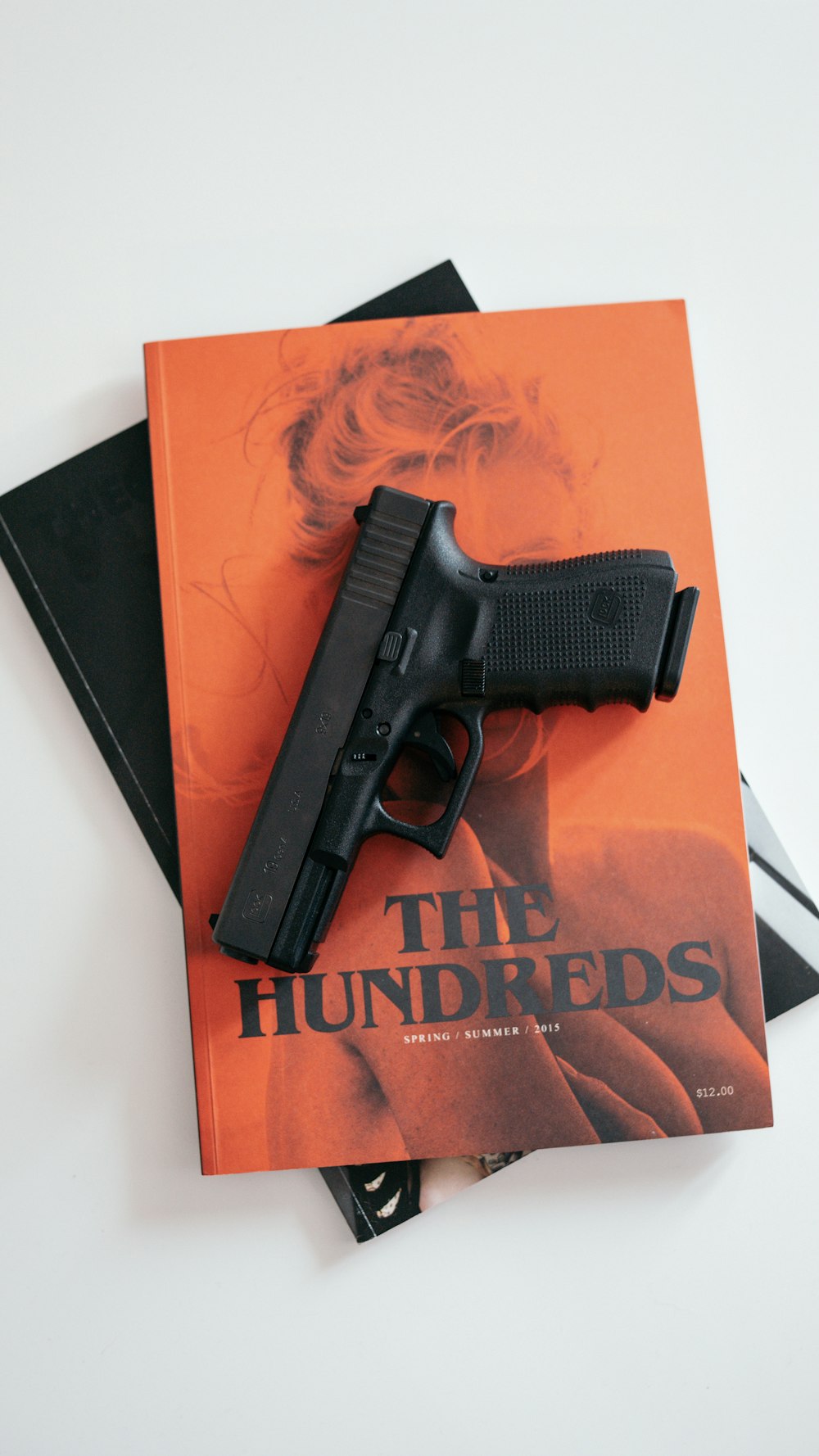 black semi automatic pistol on orange book