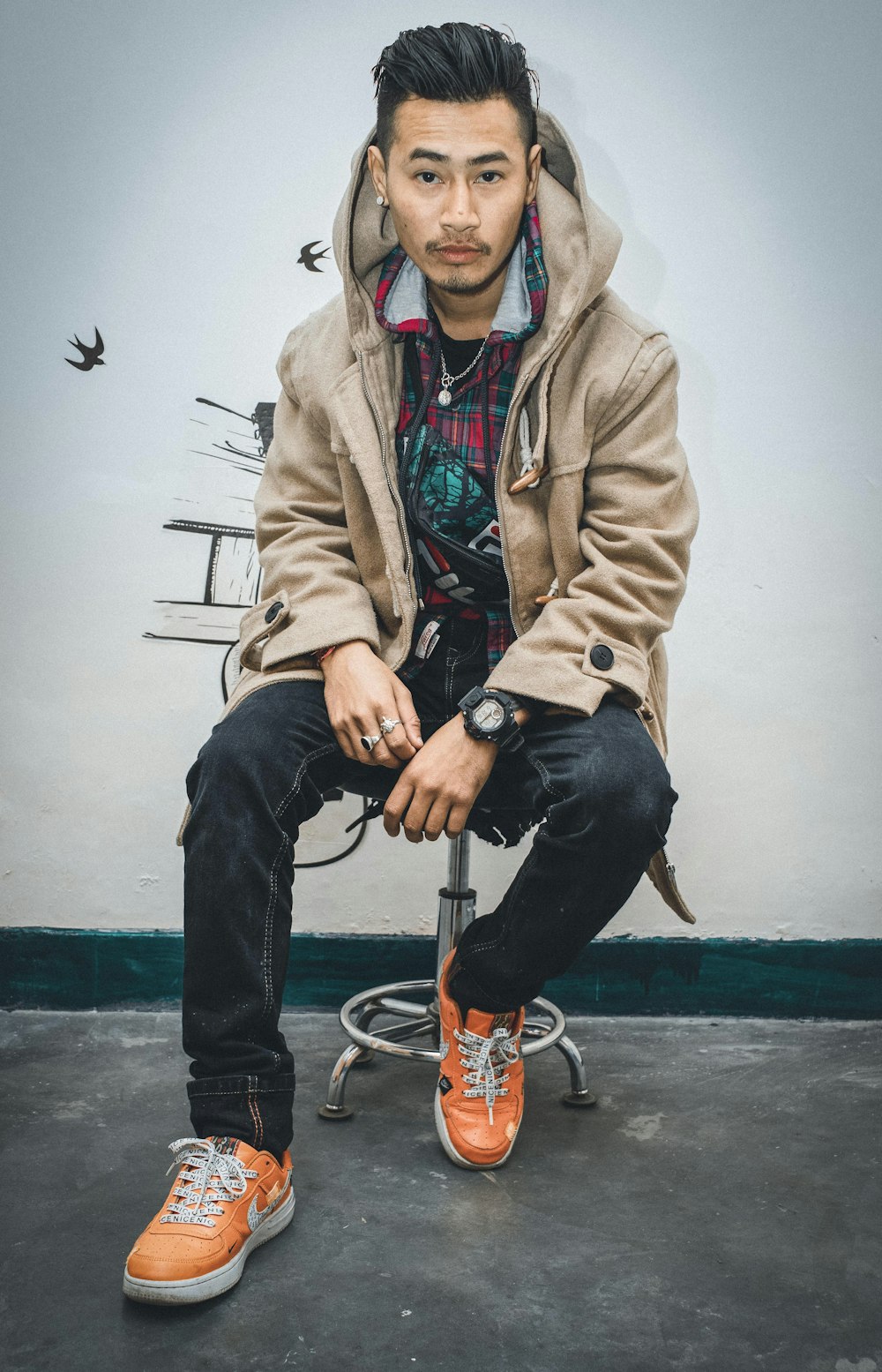 man in brown jacket and blue denim jeans sitting on brown and black bicycle