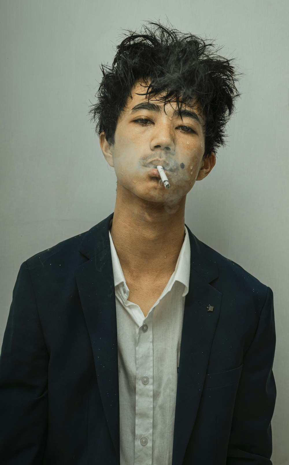 man in black suit jacket smoking