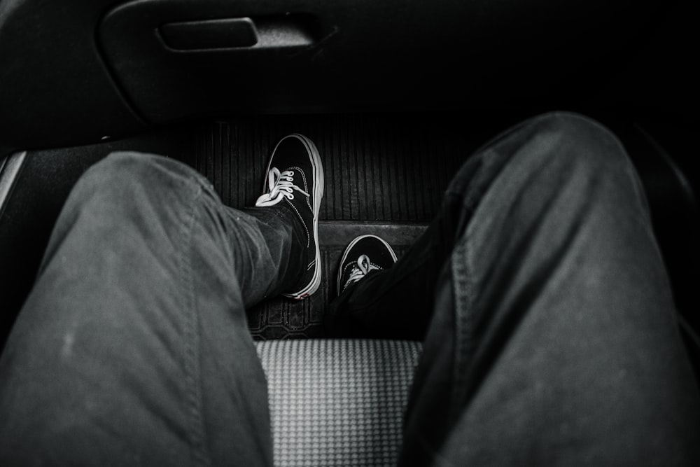 person in black pants and black and white sneakers