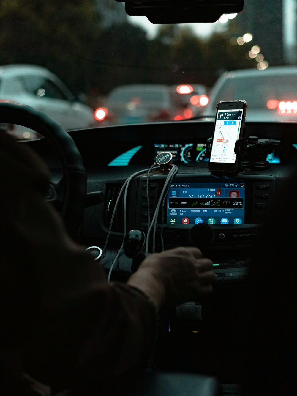 iPhone 6を手にして夜間に道路上の車の写真を撮る人