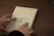 A close-up of hands unwrapping the páginaclave book from rustic packaging.