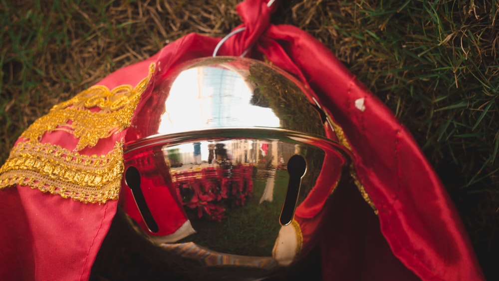 red and gold helmet on green grass