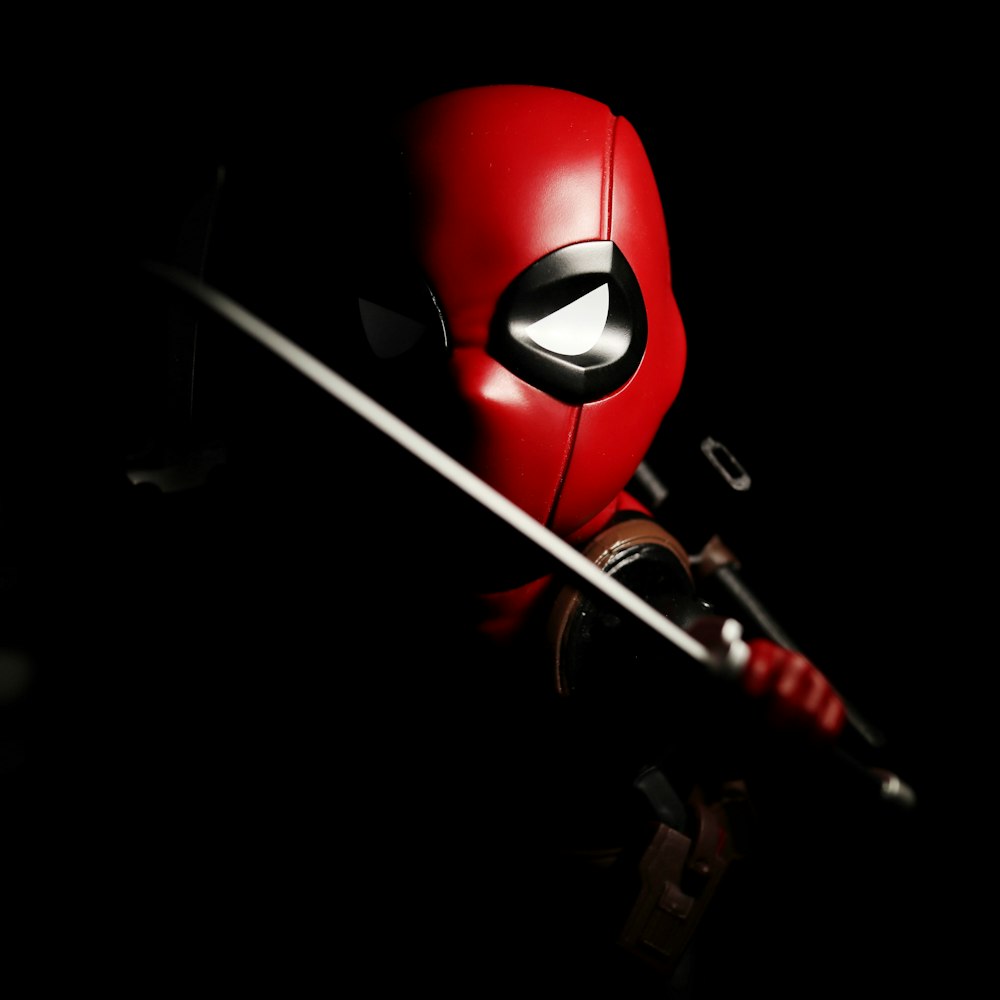red and black mask with white stick