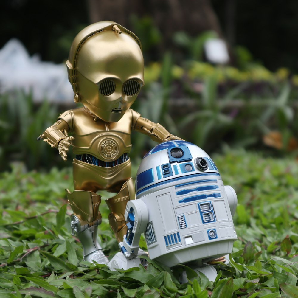 white and blue robot toy on green grass during daytime