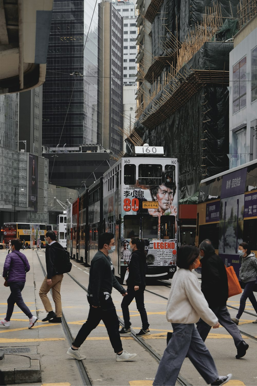 people walking on street near red tram during daytime