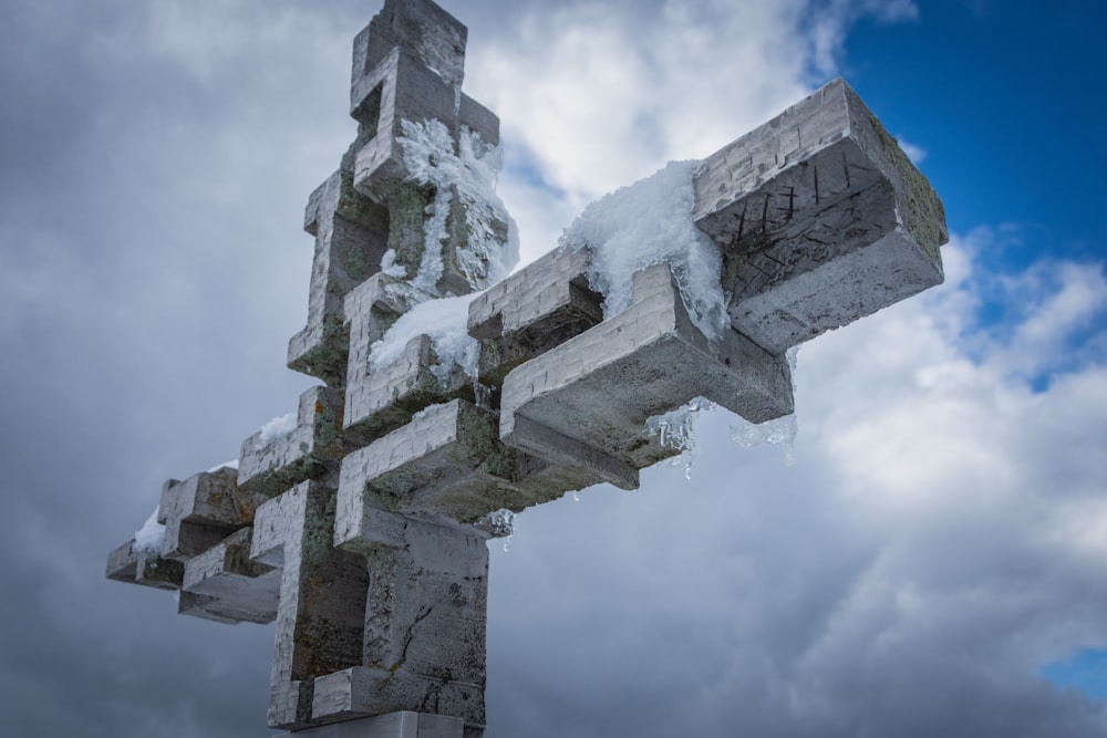 gray concrete cross under white clouds