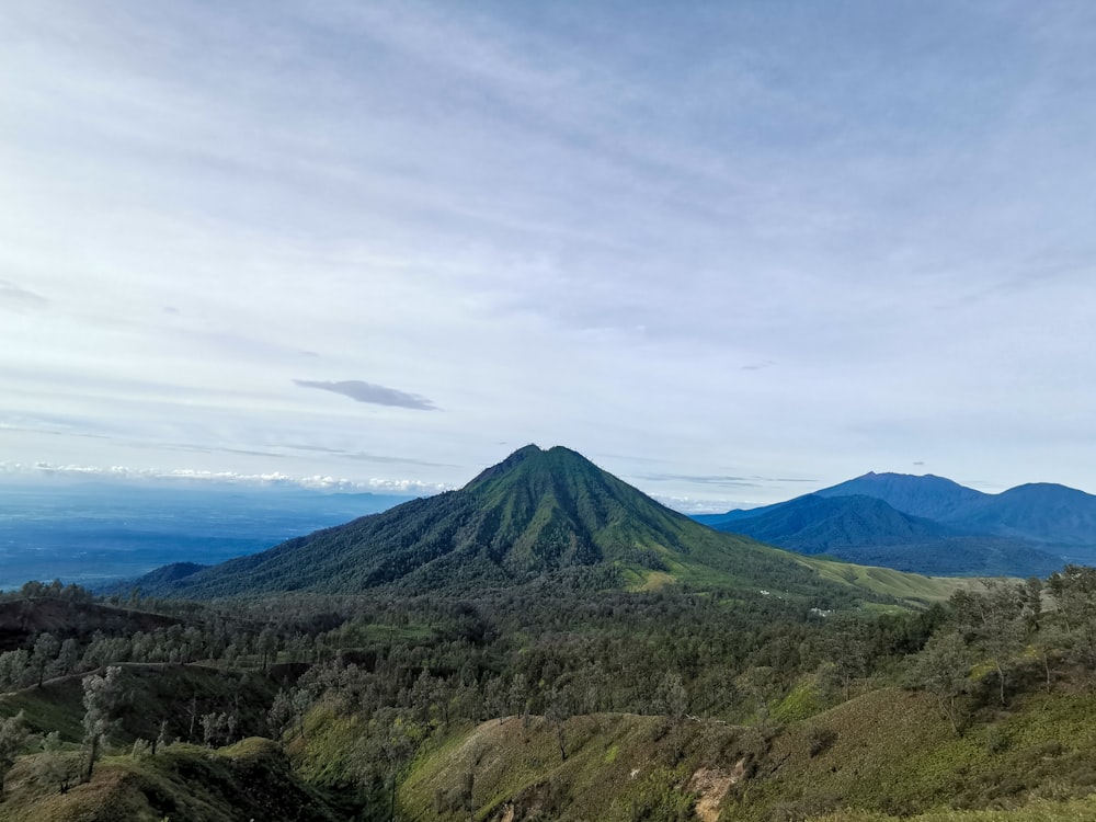 green and brown mountain under white clouds during daytime