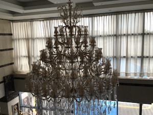 A beautifully lit custom chandelier hanging in a modern living room.