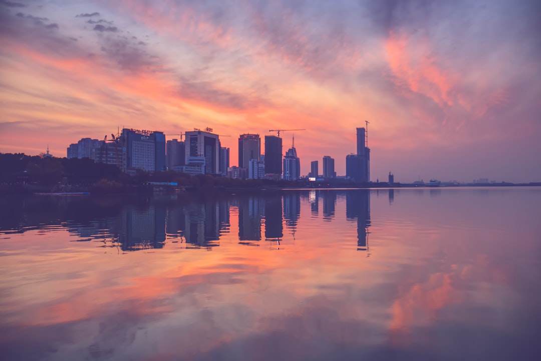 city skyline across body of water during sunset