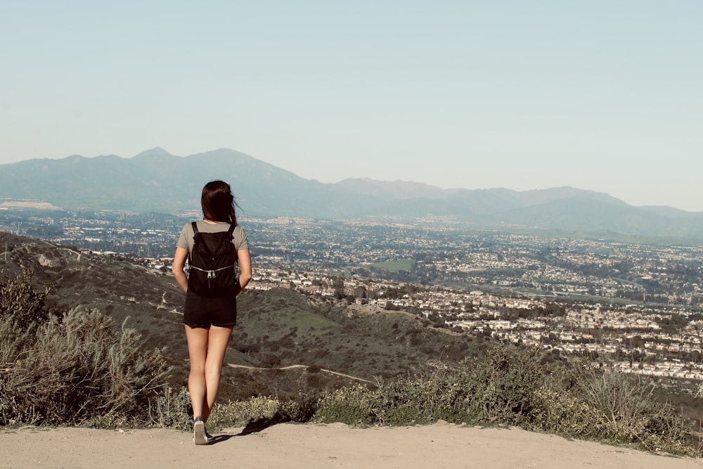 woman in black dress standing on rock formation during daytime