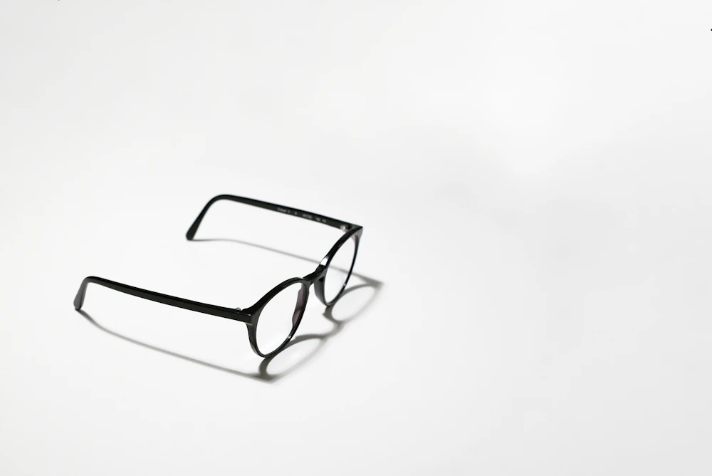 Black framed eyeglasses on a white surface