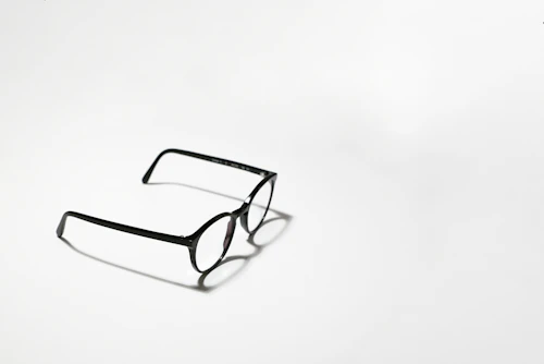 Black framed eyeglasses on white surface