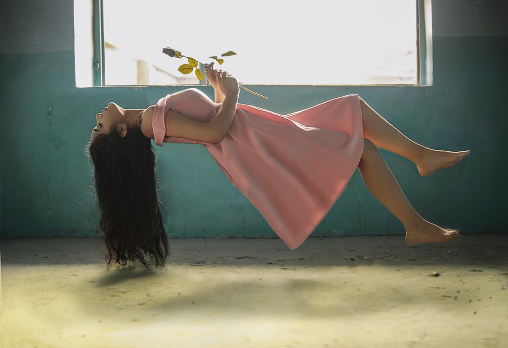 Mujer con vestido rosa sosteniendo gafas de sol negras