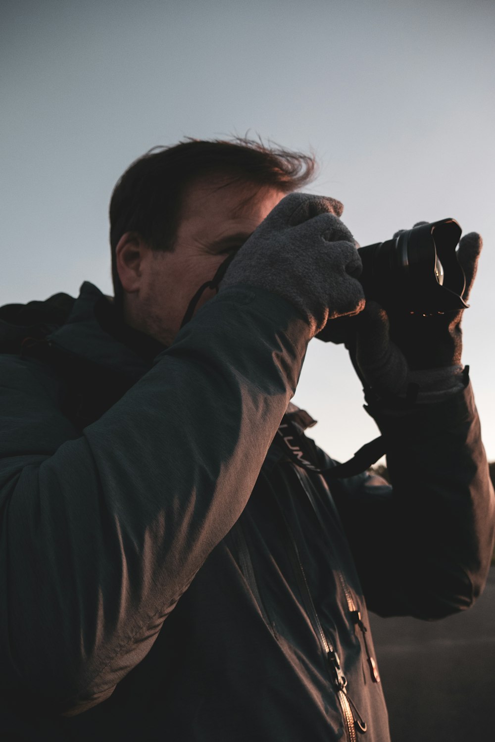 man in black jacket using binoculars during daytime