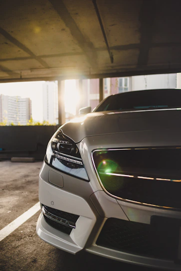 Sunlit car entrance with a sparkling clean vehicle parked, highlighting the glossy wet paint finish.