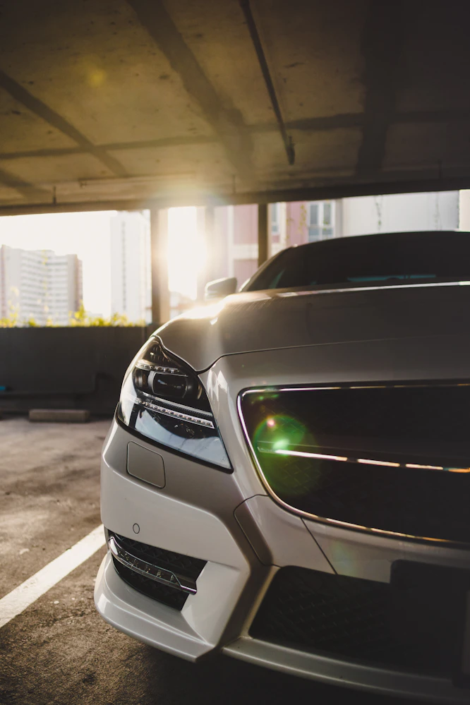 Automobilio priekinio žibinto artimasis planas saulėlydyje