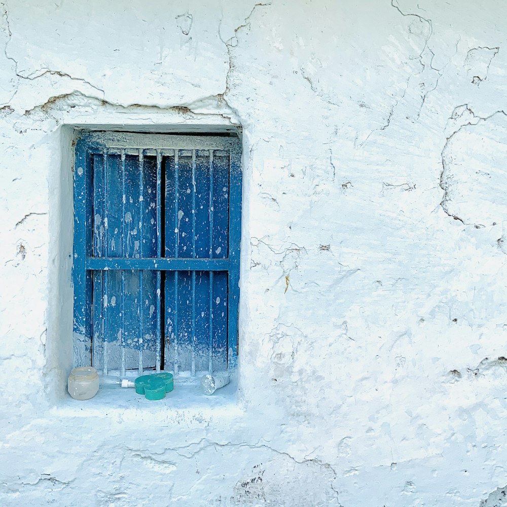 blue wooden window on white concrete wall