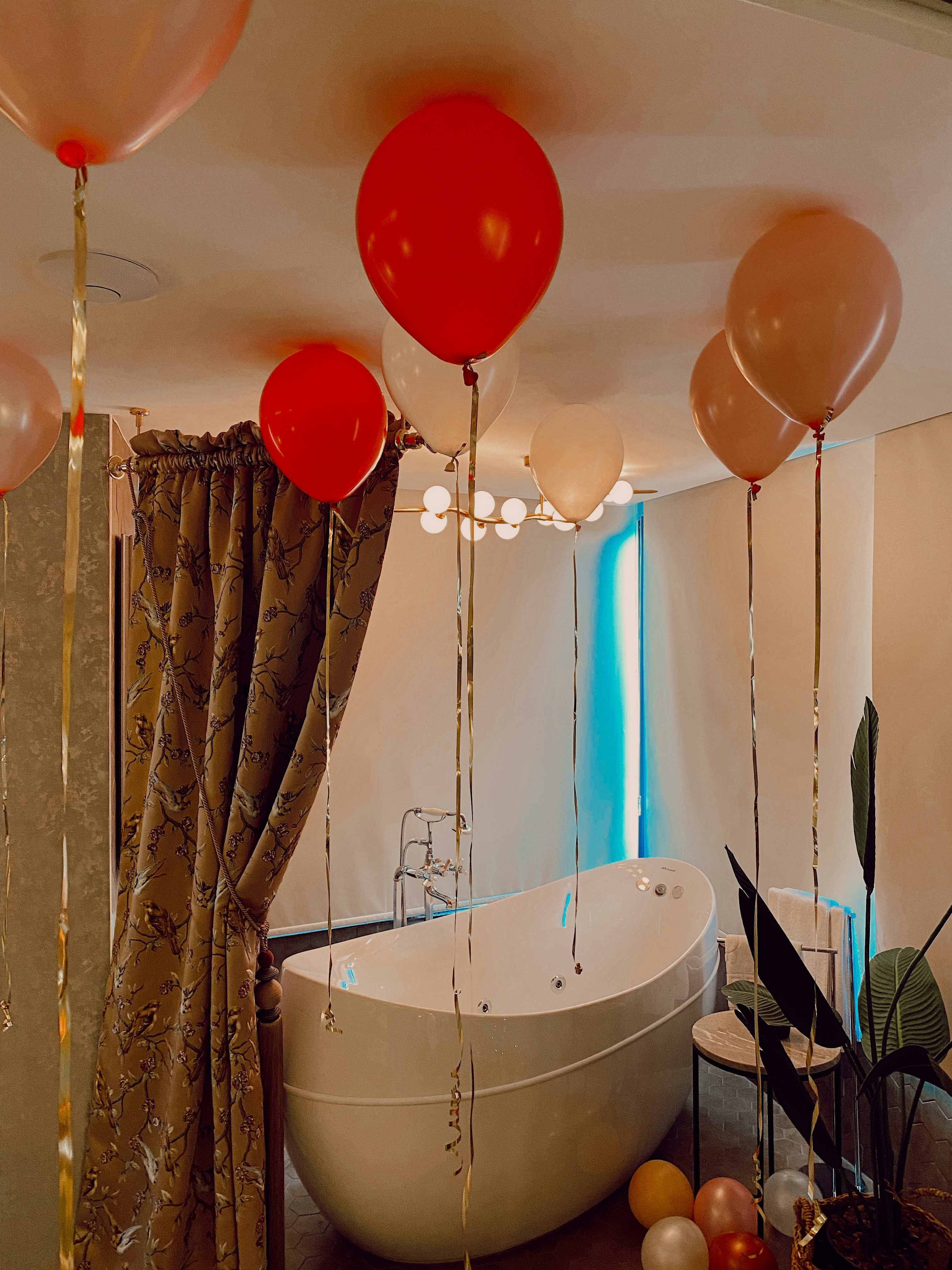 weiße Badewanne mit verschiedenen Luftballons