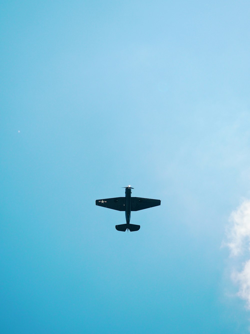 black airplane flying in the sky during daytime