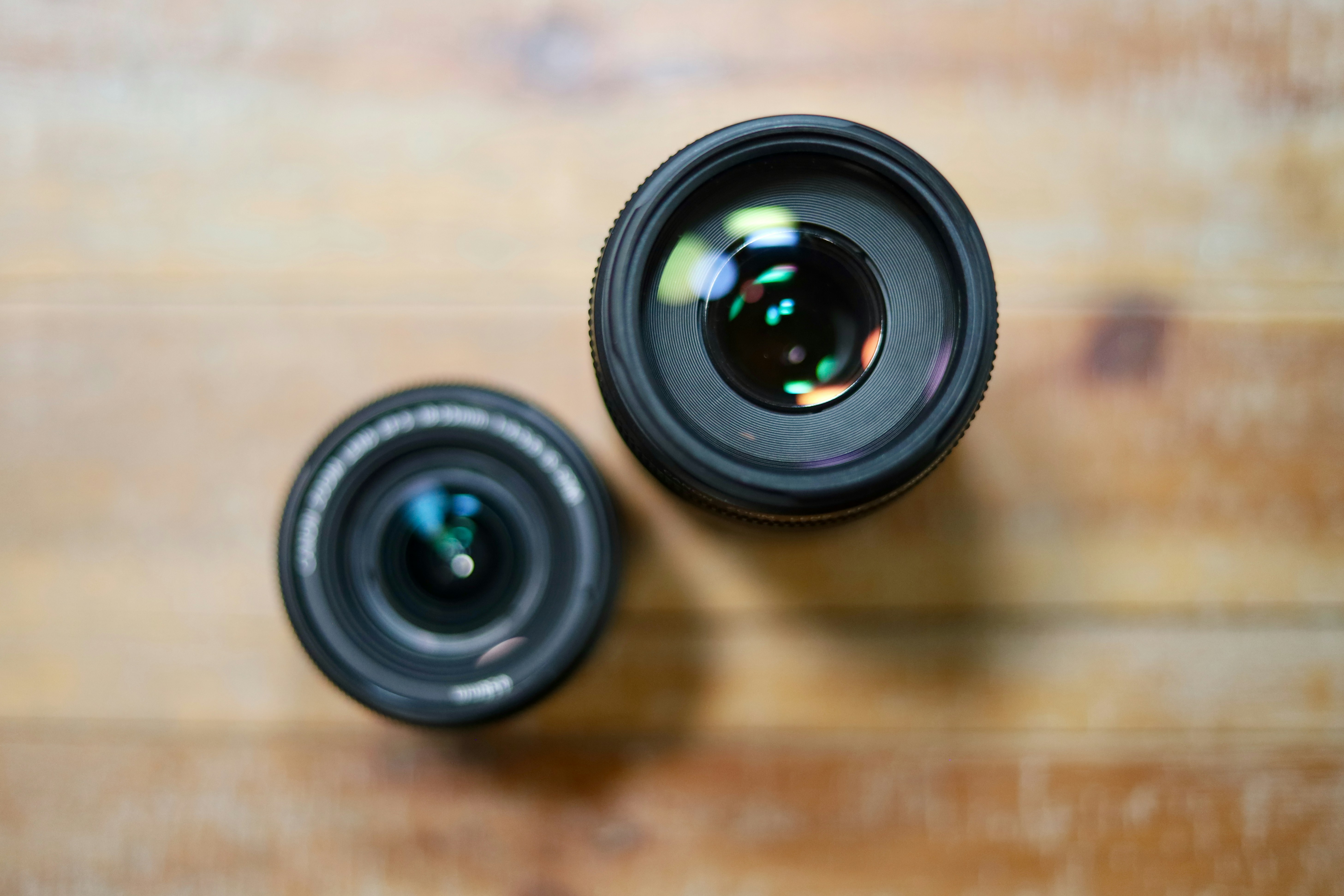 Lente de cámara negra sobre mesa de madera marrón