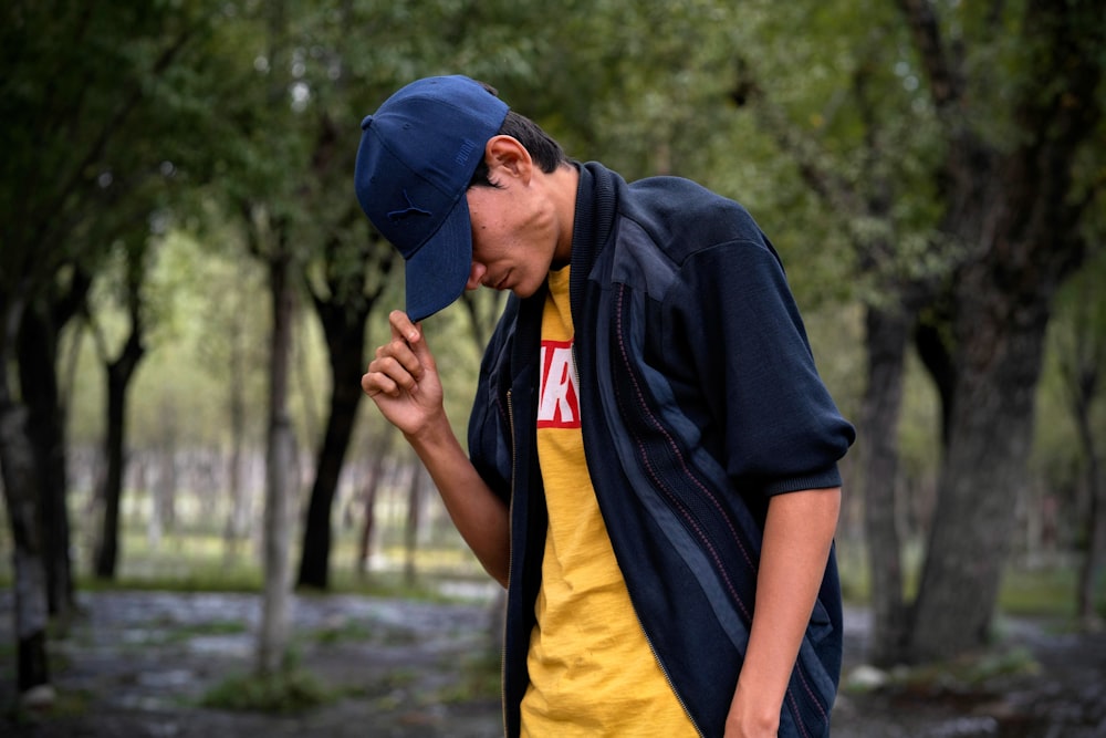 man in blue and yellow polo shirt wearing blue cap