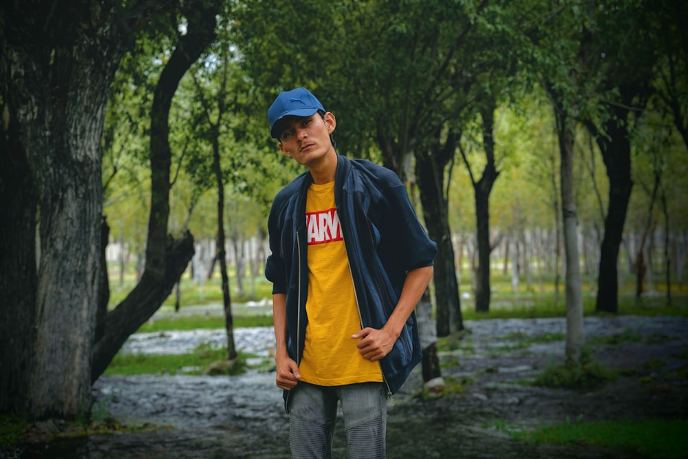 man in black and yellow adidas crew neck t-shirt and gray denim jeans standing on near near near near