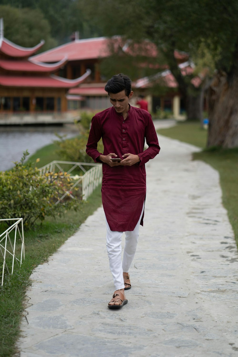 man in red long sleeve shirt and red pants standing on gray concrete pavement during daytime