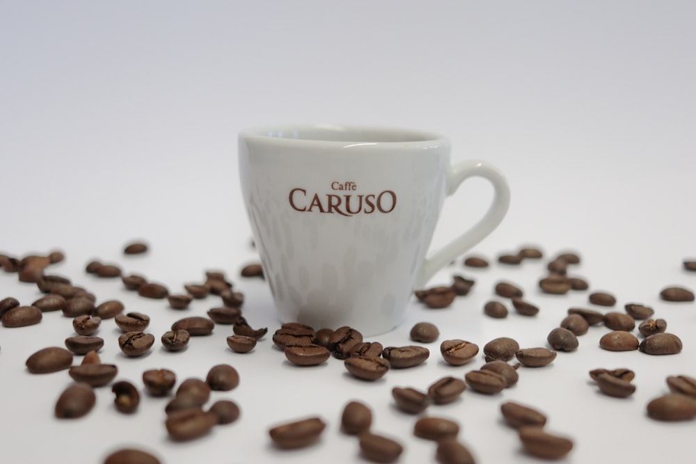 white ceramic mug with coffee beans