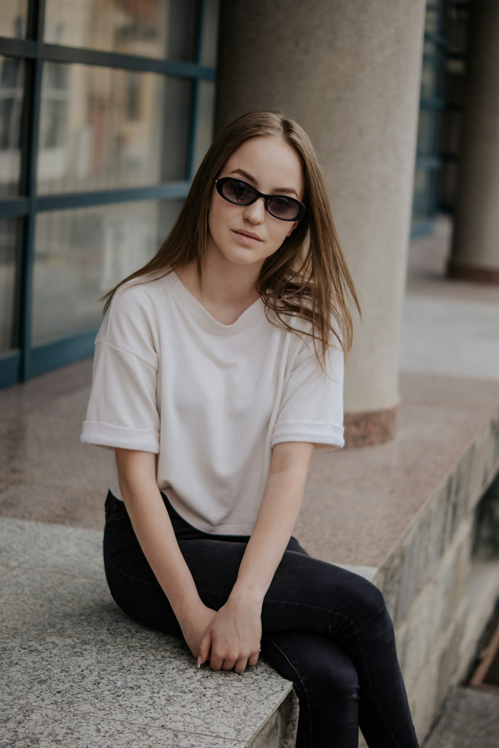 George Hanbury Automatisk kolbøtte woman in white crew neck t-shirt and black pants sitting on concrete bench  photo – Free Clothing Image on Unsplash