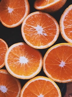 Close-up of vibrant orange slices glistening with fresh juice droplets on a white background