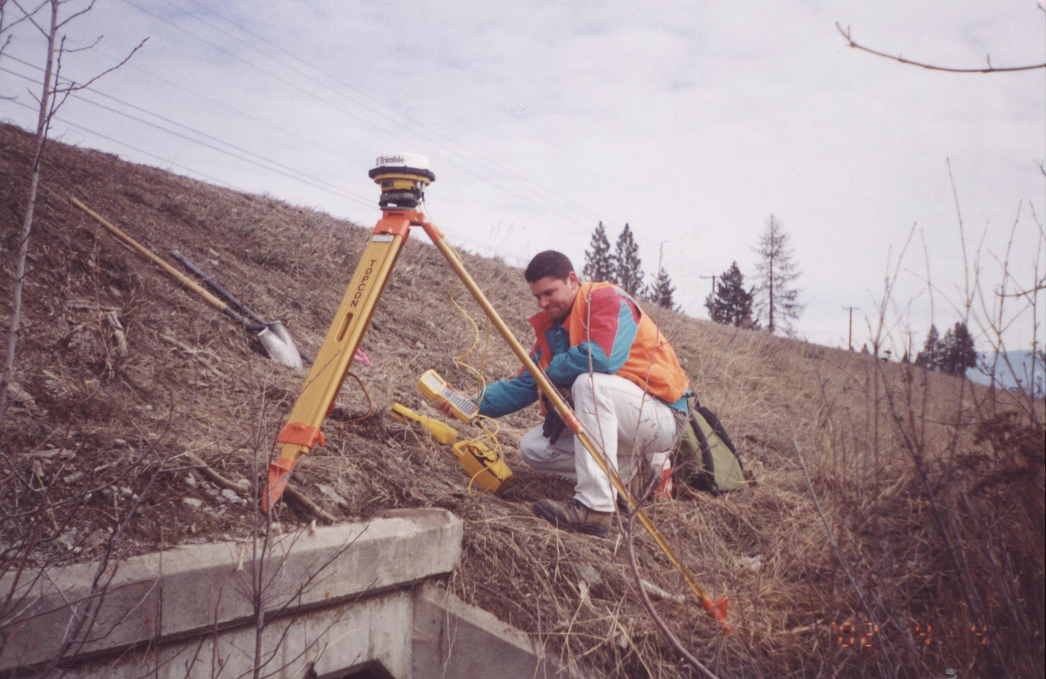 man in red jacket sitting on brown wooden ladder during daytime