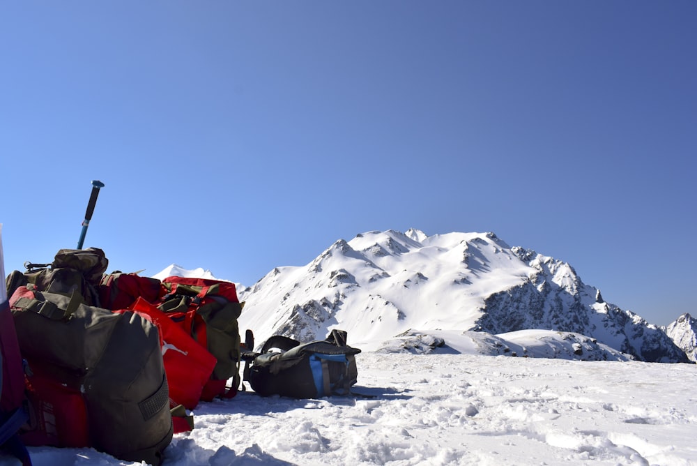 a pile of luggage sitting on top of a snow covered slope