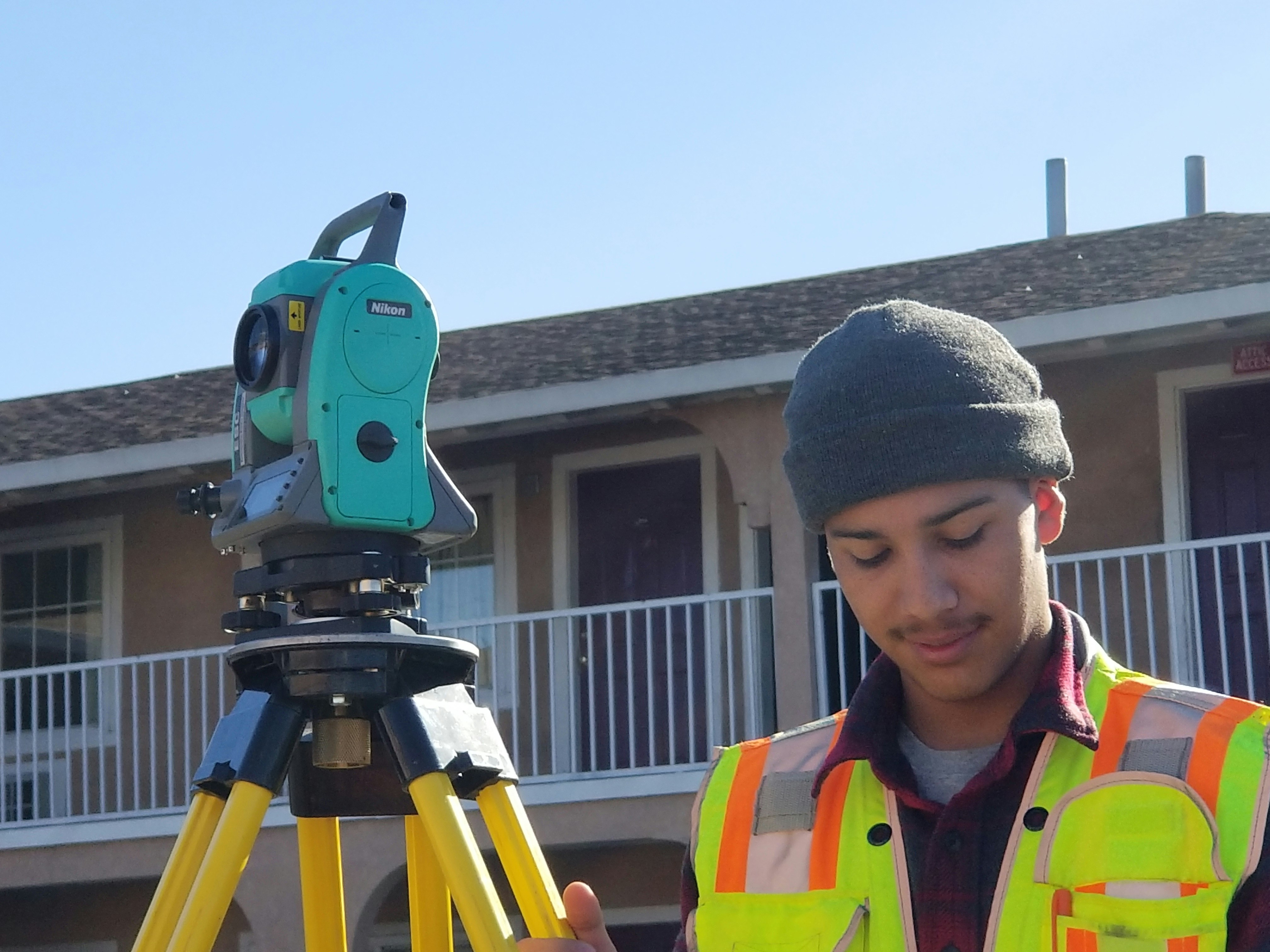 boy in black knit cap holding green and black toy gun