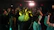 A vibrant dance group moving together in a bright, cheerful room.