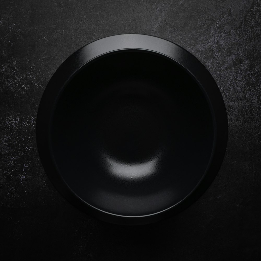 schwarze runde Platte auf schwarzer und grauer Oberfläche