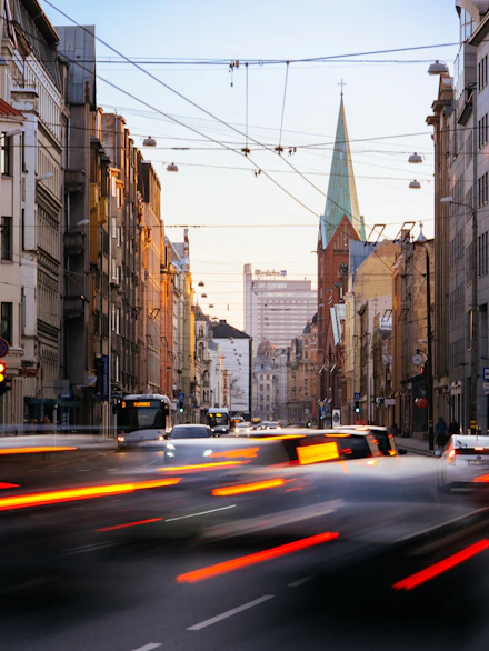 cars on road between high rise buildings during daytime