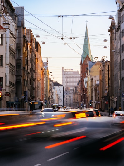 cars on road between high rise buildings during daytime