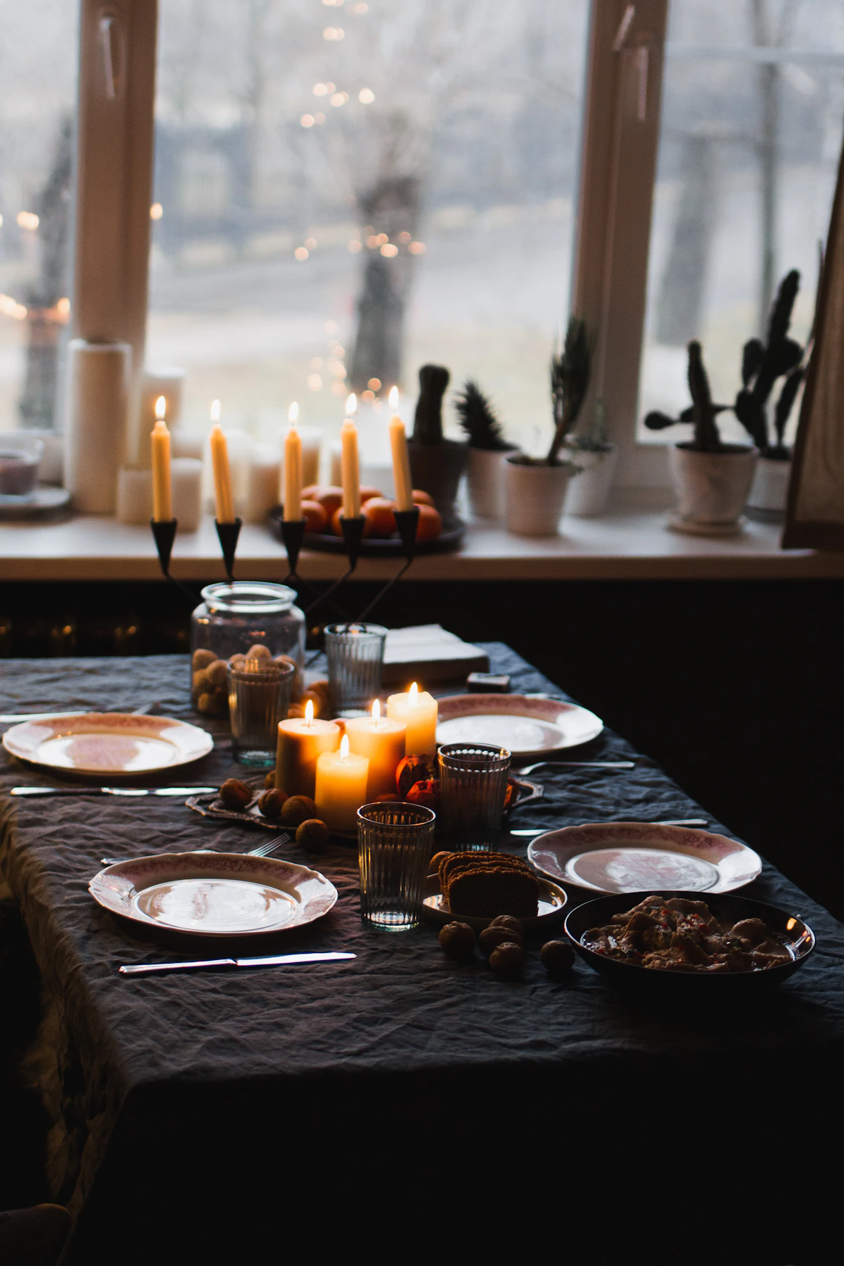 Lit candles arranged on a round dinner table