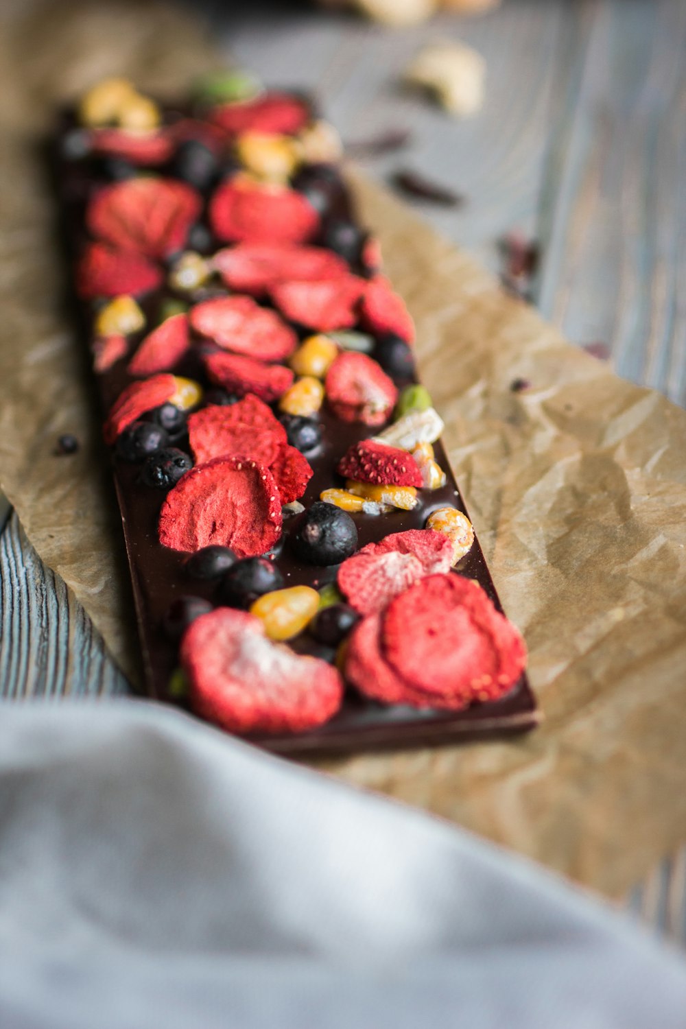 sliced strawberries and blueberries on brown wooden tray