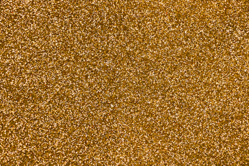 Golden nano powder spread evenly on a black surface highlighting texture.
