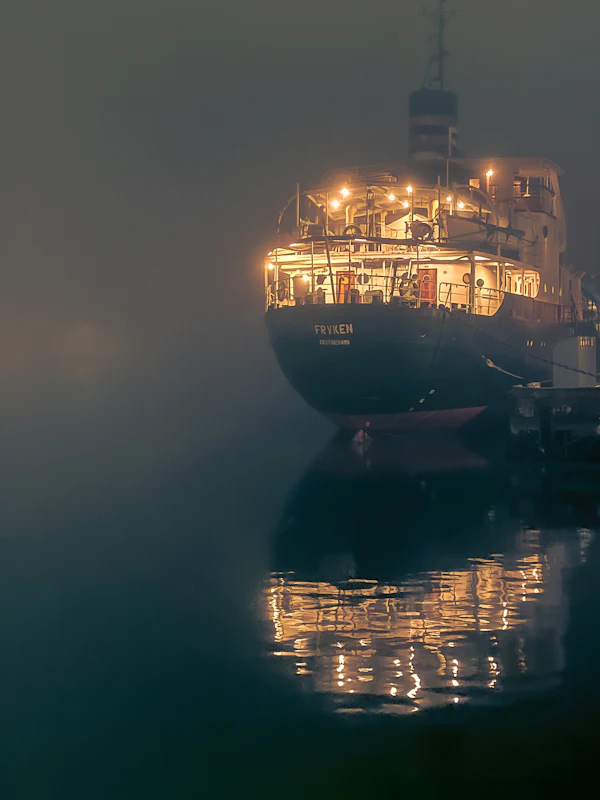 A lit boat on the Seine at night