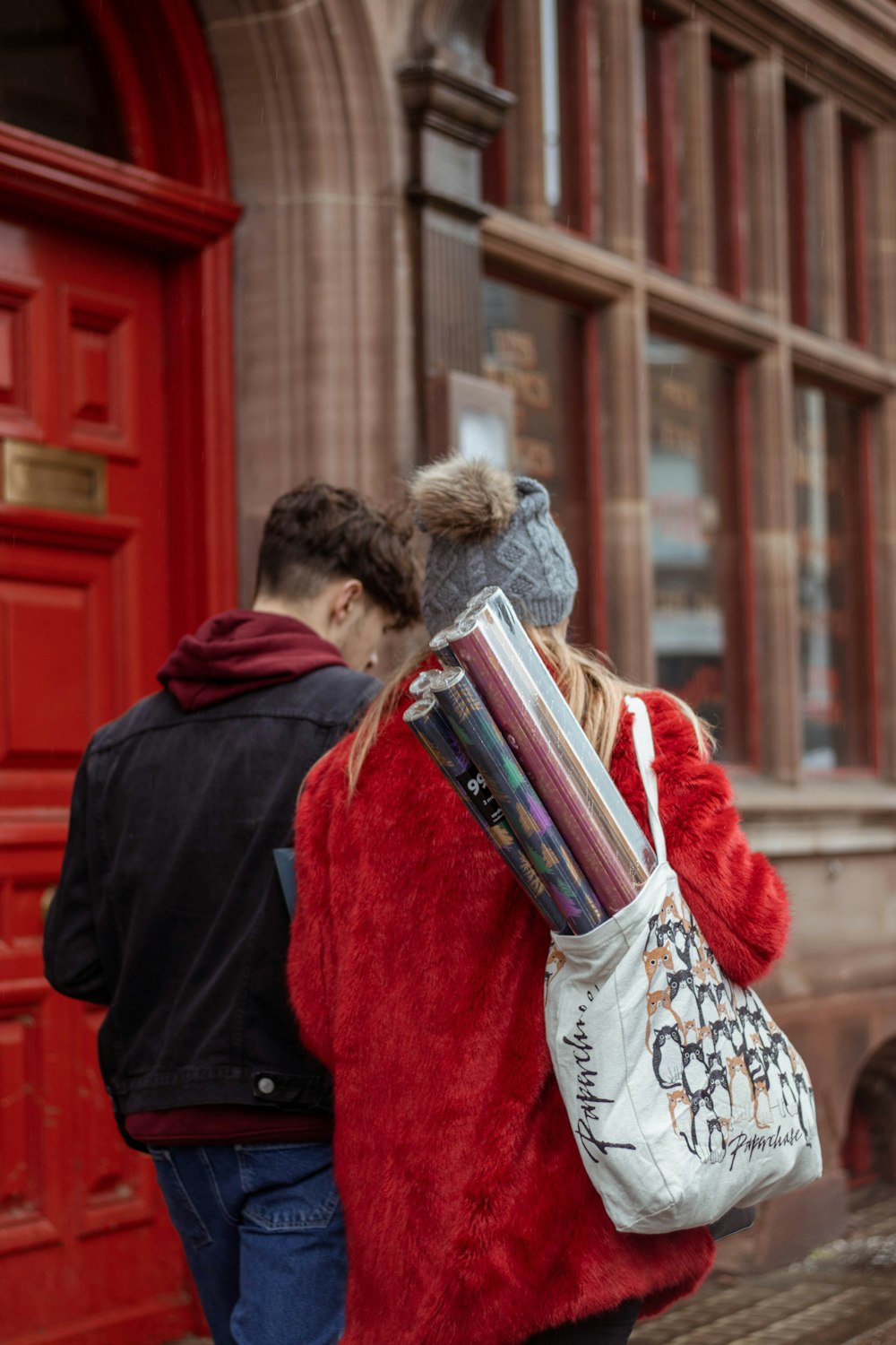 woman in red coat holding book