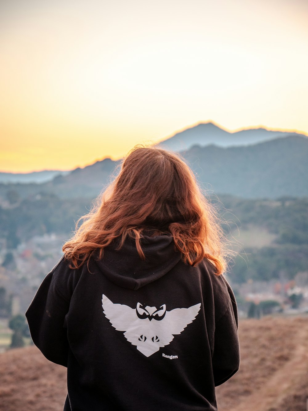 woman in black hoodie standing on brown field during daytime