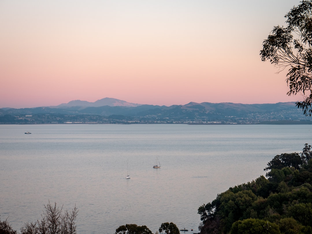 body of water near mountain during daytime